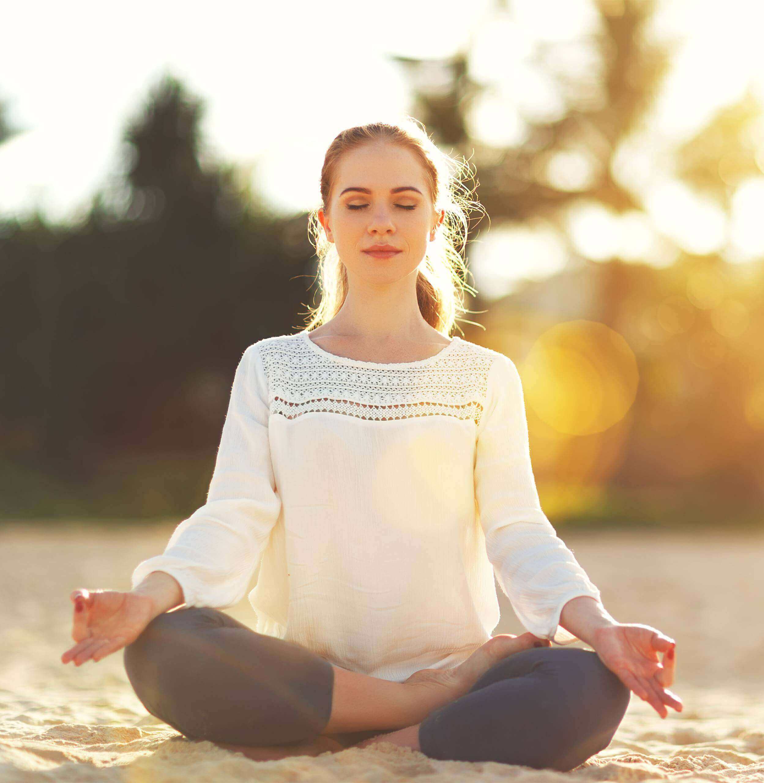 Moving Minds Hypnotherapy - woman meditating in the sand