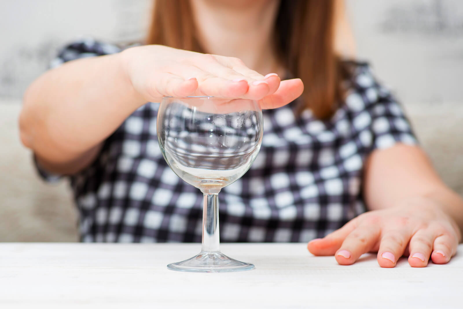Moving Minds Hypnotherapy - a woman's hand covering the top of the wine glass