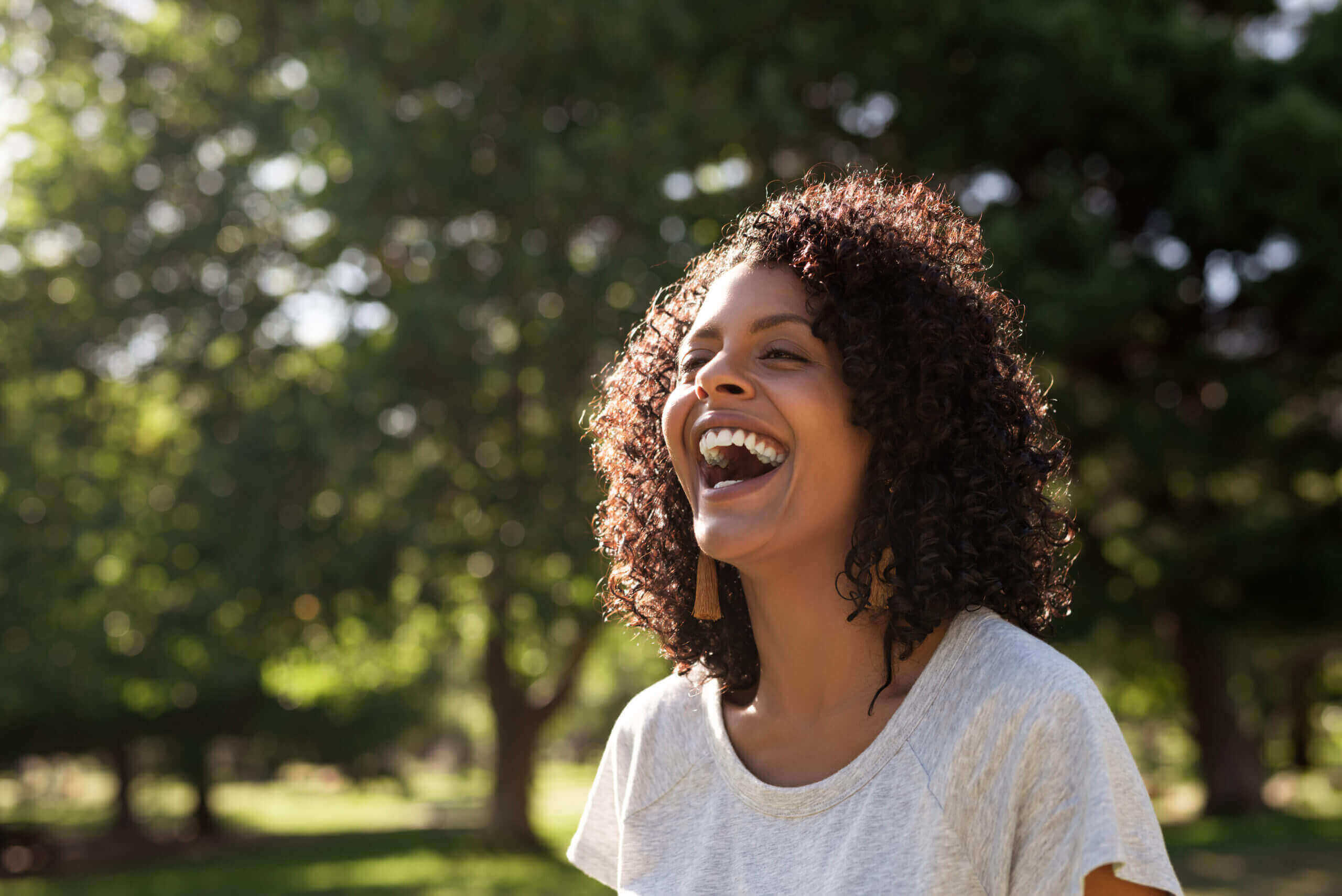 Moving Minds Hypnotherapy - curly woman laughing